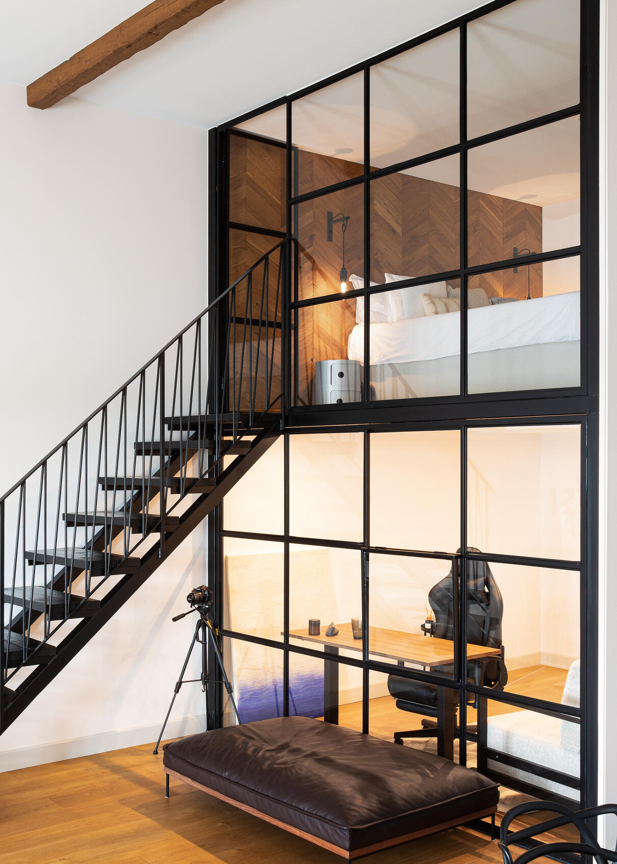 Black steel staircase and glass partition enclosing a home office and mezzanine bedroom. Black steel staircase and glass partition enclosing a home office and mezzanine bedroom.